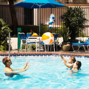 family playing in the pool at Howard Johnson Anaheim hotel