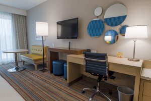 New retro guest rooms with a tv, desk, and table