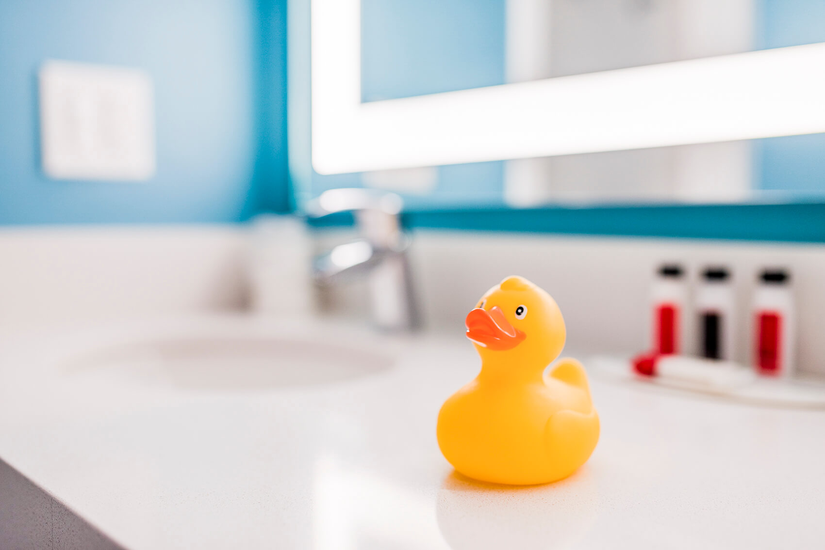 a rubber ducky sits on a hotel room bathroom