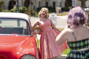 one of Howard Johnson Anaheim's retro friends poses near a retro car