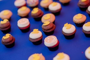 tiny cupcakes are decorated with smiles and rubber ducks