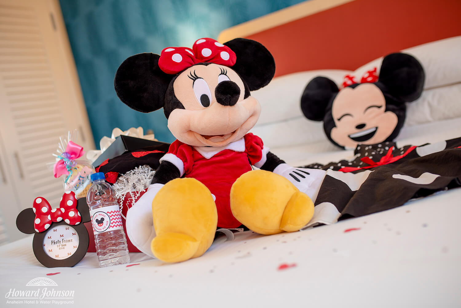 Minnie Mouse themed items sit on a hotel room bed
