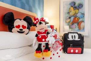 Mickey and Minnie Mouse themed accessories and decor sit on a hotel room bed