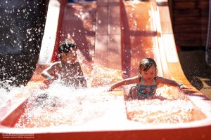 two children slide down a slide at Castaway Cove