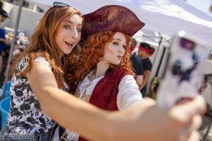 a woman takes a selfie with a woman dressed as a pirate