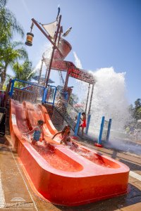 two children slide down a slide at Castaway Cove