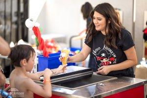 a woman passes a frozen treat to a child