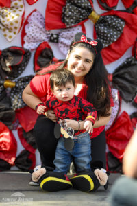 a woman and her young boy pose for a picture in front of a backdrop of polka dot bows