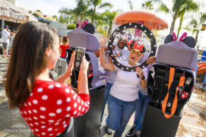 a woman and man pose for a picture with a circular polka dot frame and sunglasses that a woman takes with her phone