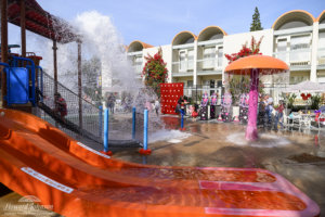 a wide shot of children and parents playing at the water playground at the Howard Johnson Anaheim hotel