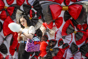 a young woman is pictured with blue cotton candy in front of a backdrop of polka dot bows