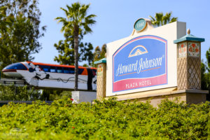 A Disneyland tram passes by a sign for the Howard Johnson Anaheim hotel