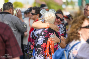 two women who are a part of the Mattercammers United embrace in a hug in the middle of a crowd of people