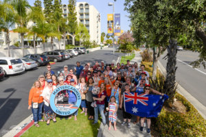 a group of people holding a sign identifying them as Mattercammers United pose for a picture with Howard Johnson Anaheim in the background