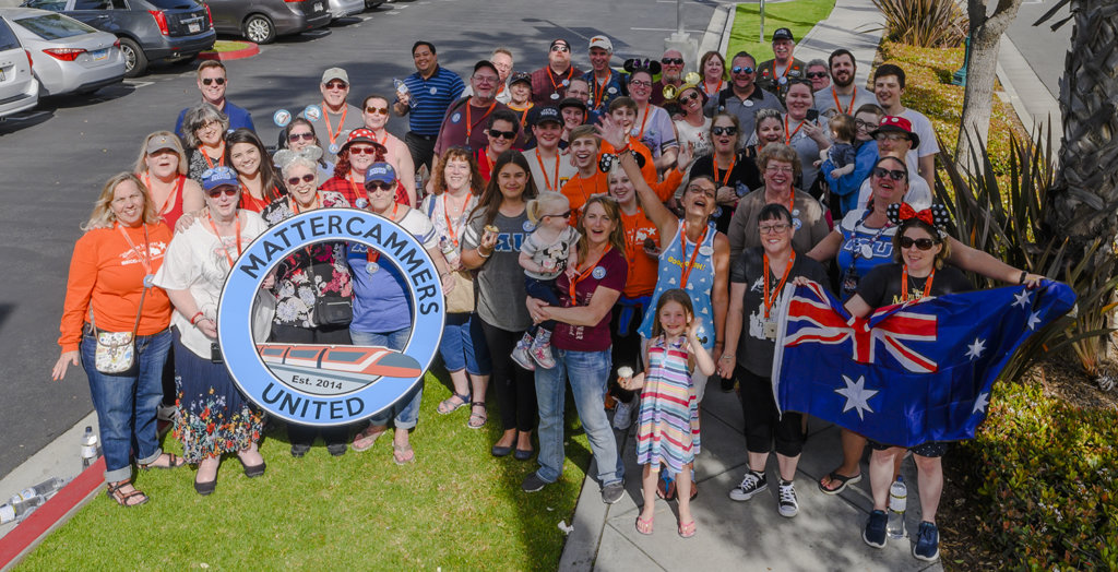 a group of people pose for a picture with a sign, identifying them as Mattercammers United